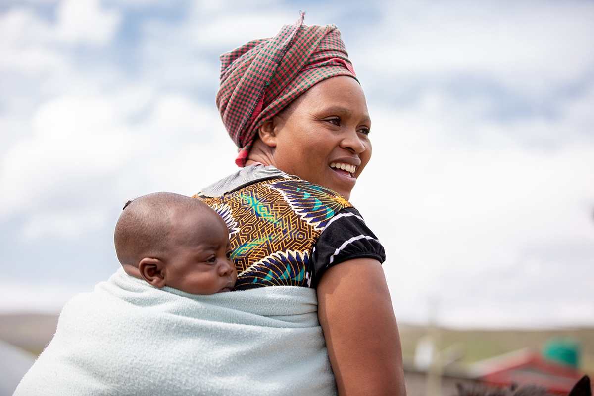 A mother carries her 4-month-old infant on her back following their well child visit in Lesotho.