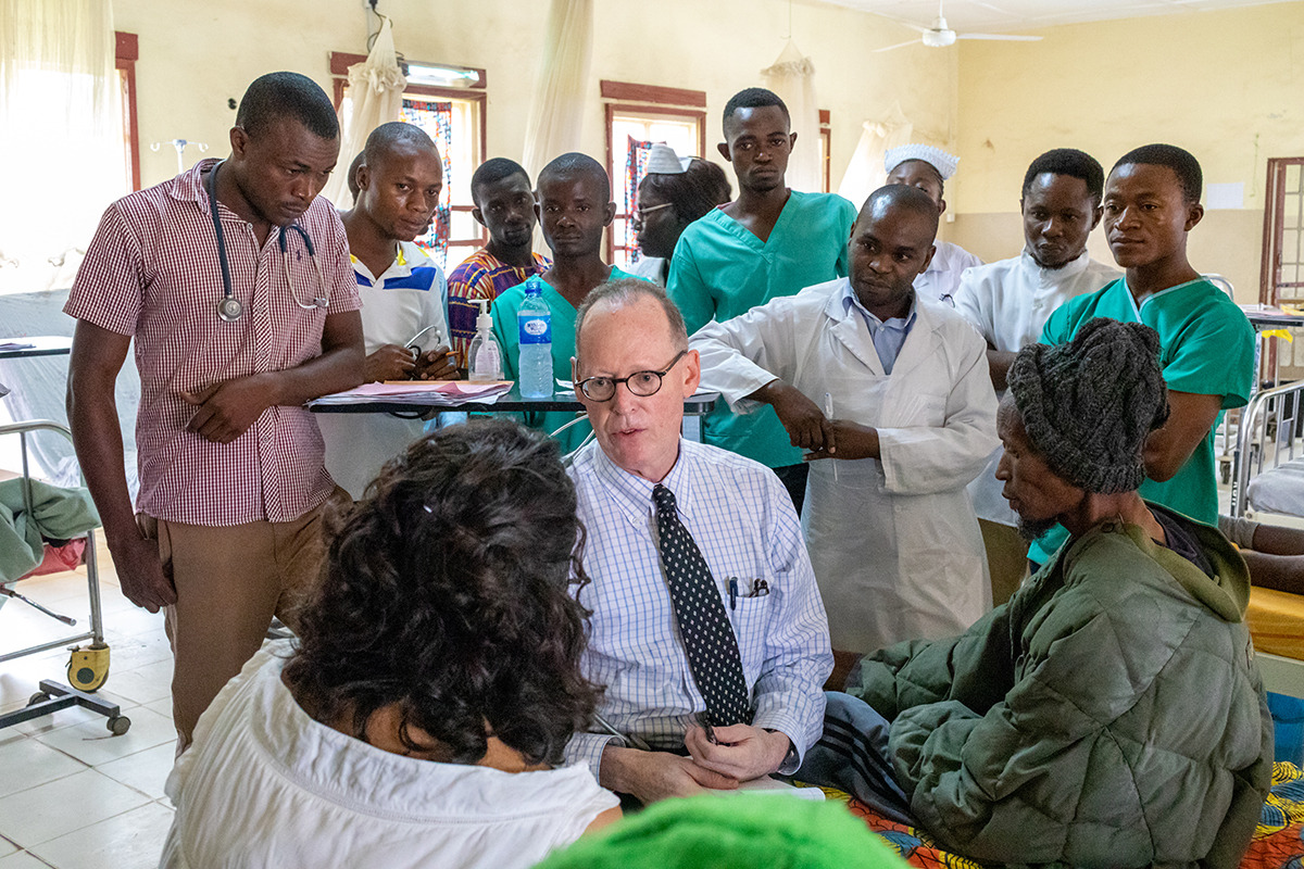 Paul Farmer and clinical staff consulting a patient in Sierra Leone