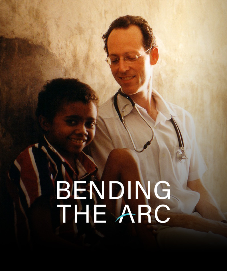 Dr. Paul Farmer sitting next to a child