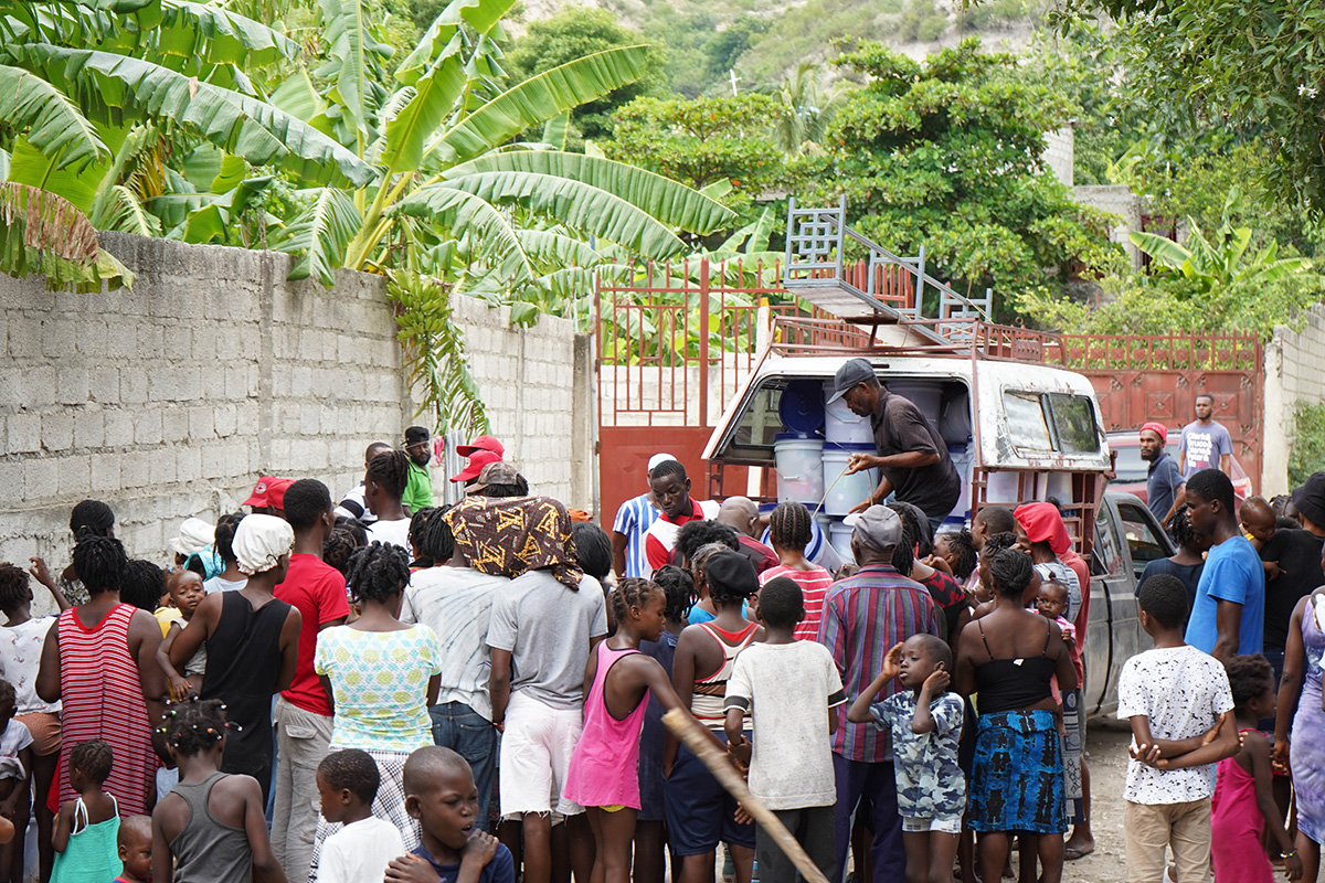 Humanitarian aid workers distributing supplies from a van.