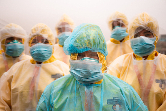 Caregivers standing together wearing protective equipment