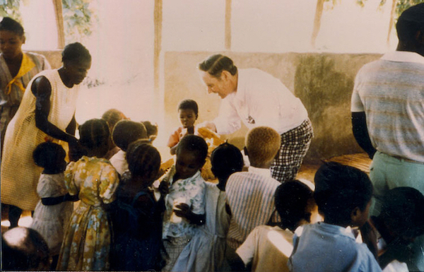 Tom white with children of Haiti