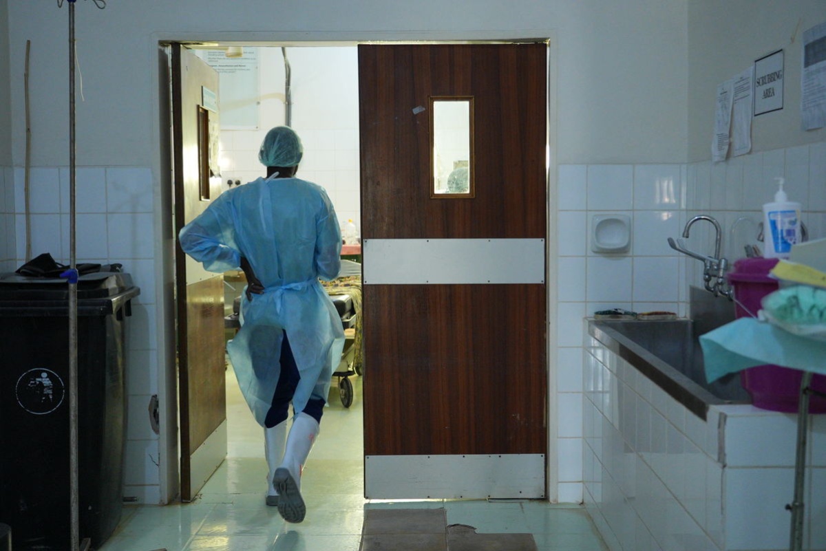 A health worker walks into an operating room in Malawi.