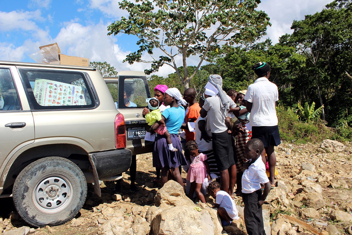 Residents of Jeannin in the area of St. Marc line up for food assistance from a Zanmi Lasante mobile clinic in Haiti.