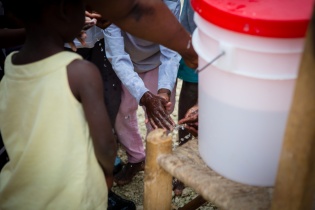 children wash hands during a cholera prevention campaign in Haiti