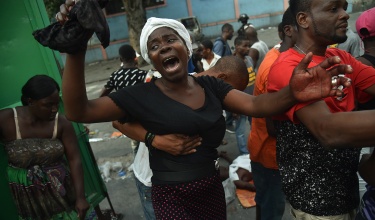 A mother cries beside the body of her son, who was shot and killed during clashes between Haitian police and demonstrators Feb. 9 in Port-au-Prince. 