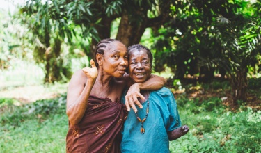 Civil war survivors who suffered amputations embrace in Sierra Leone