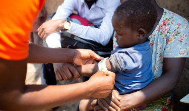 a child in Malawi has her mid-upper arm circumference measured for malnutrition