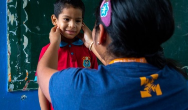Nurse Nataly Cueva screens a student’s health at an elementary school in Carabayllo, Peru.