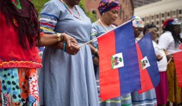Women hold hands on Haitian Flag Day in Boston