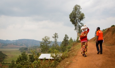 Jean Bosco Bigirimana, right, on the way to a home visit in Rwanda