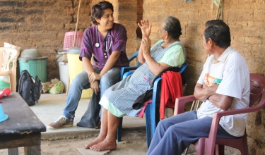 Each year, Partners In Health trains a new cohort of 10 first-year clinicians, who work in rural communities in Chiapas, Mexico. In this photo, a pasante speaks with patients in Chiapas.