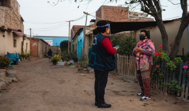 A staff member with Socios En Salud, as PIH is known in Peru, does a door-to-door mental health screening with a patient after a chatbot app connected them.