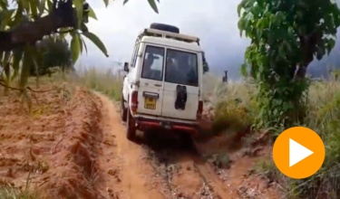 A scene of a truck driving on an uneven, dirt road in Malawi 