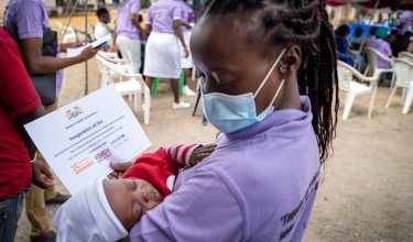 A clinician holds Naphtal, who was safely delivered in the Special Care Baby Unit at PIH Sierra Leone