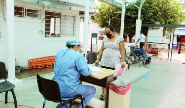 In Mexico, a nurse in PPE helps a patient in the triage area of the hospital.
