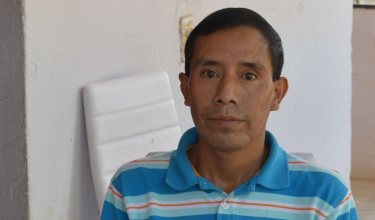Tuberculosis patient Abelino Hernández poses for a picture in a blue striped shirt.