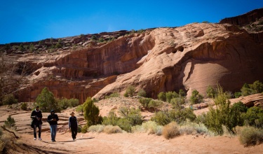 Three people walk in Canyon de Chelly in Navajo Nation, where hundreds of abandoned uranium mines continue to pollute the environment.