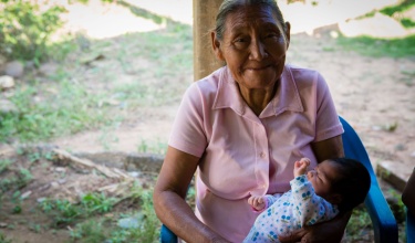 Margarita Perez Jimenez, a traditional midwife, holds an infant she delivered.