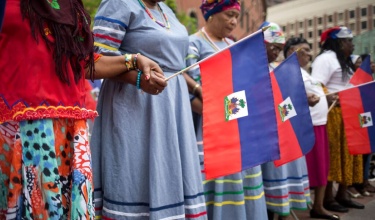 women hold Haitian flag in downtown Boston