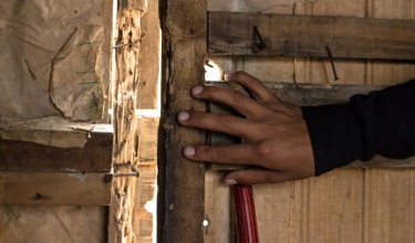 A man's hand covers a door in northern Lima, where Socios En Salud works.