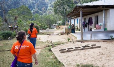 Community health workers approach a home in Laguna Del Cofre for a house call.