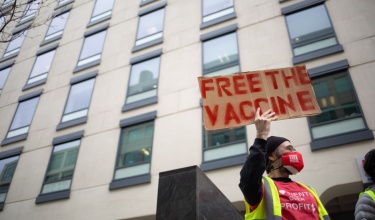 A protestor holds a sign that says "Free The Vaccine" in Cambridge, Massachusetts.