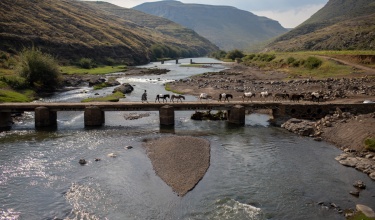 Local residents cross a one-lane bridge near PIH-supported Bobete Health Center in Thaba-Tseka District, Lesotho