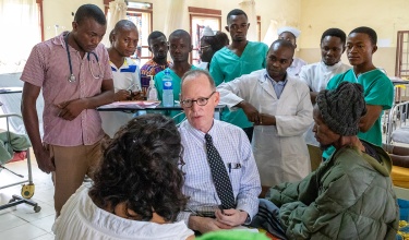 Paul Farmer and clinical staff consulting a patient in Sierra Leone