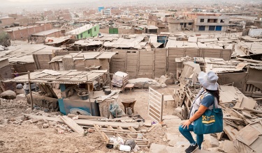 A community health worker with Socios En Salud, as Partners In Health is known in Peru, climbs to visit a patient at home.