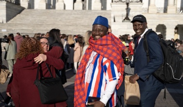 Jen Furin, tuberculosis expert, hugs PIH Principal Chief Program Officer Cate Oswald while Stephen K. McGill, executive director of Stop AIDS in Liberia, and Dr. Melino Ndayizigiye, executive director of PIH Lesotho, join the crowd gathering at the steps of the Capitol for the 2025 TB Hill Day.